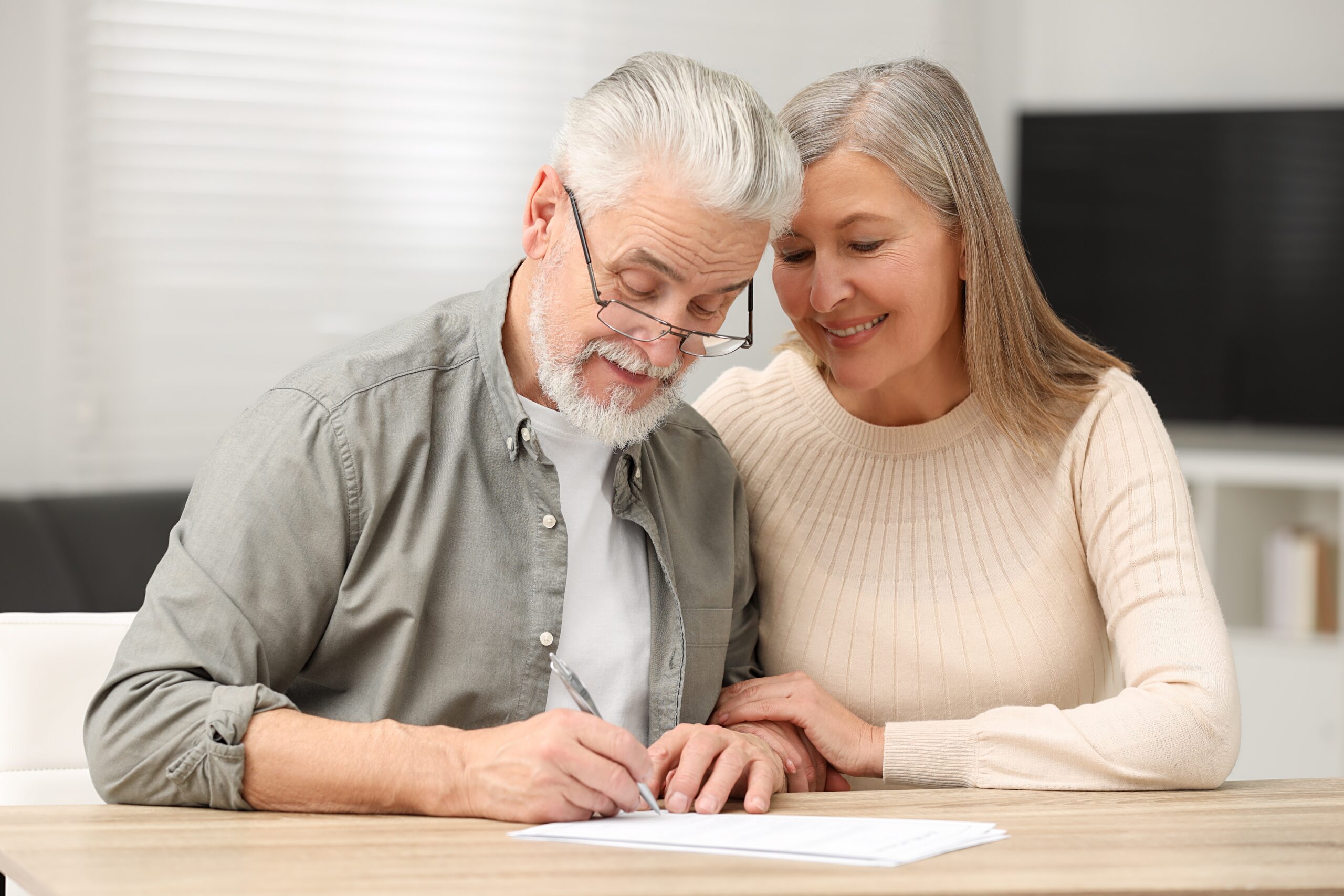Elderly couple signing paper for probate solicitors Colchester