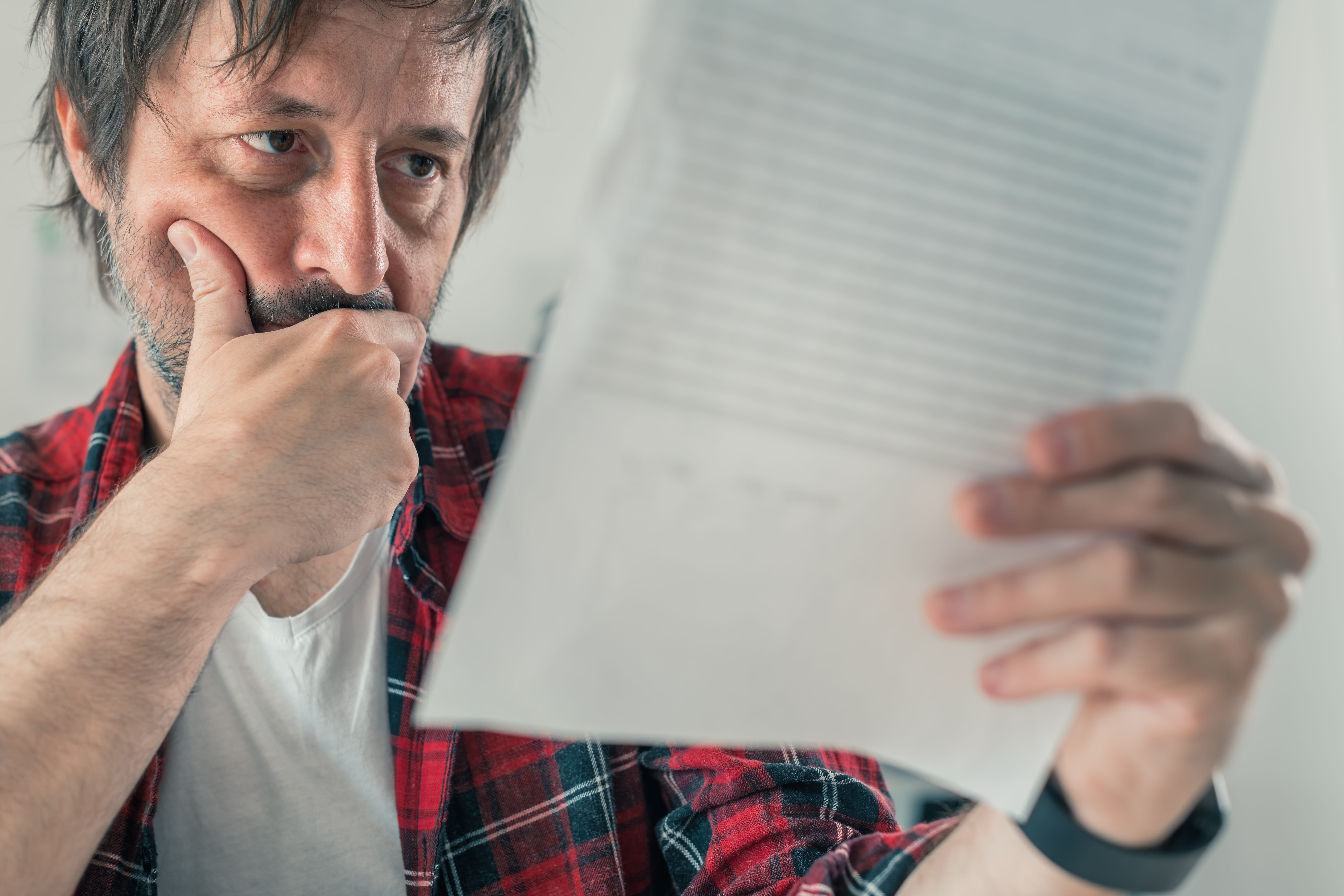 Man in red checked top and beard reads document wondering if he can challenge a Will